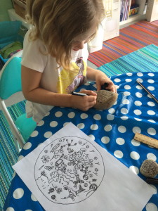 Mandala drawing on paper and a river stone.