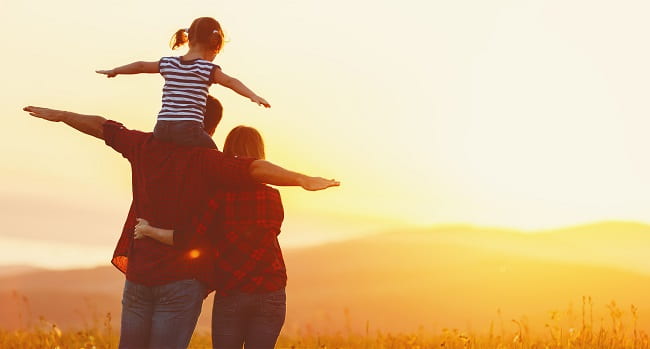 family watching sunset child on shoulders